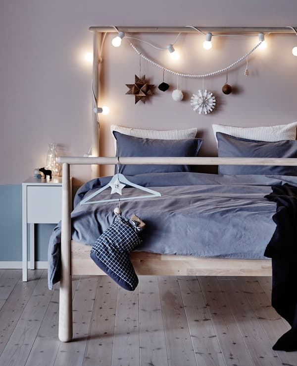 Décorations et de guirlandes lumineuses accrochées à la tête d'un lit.