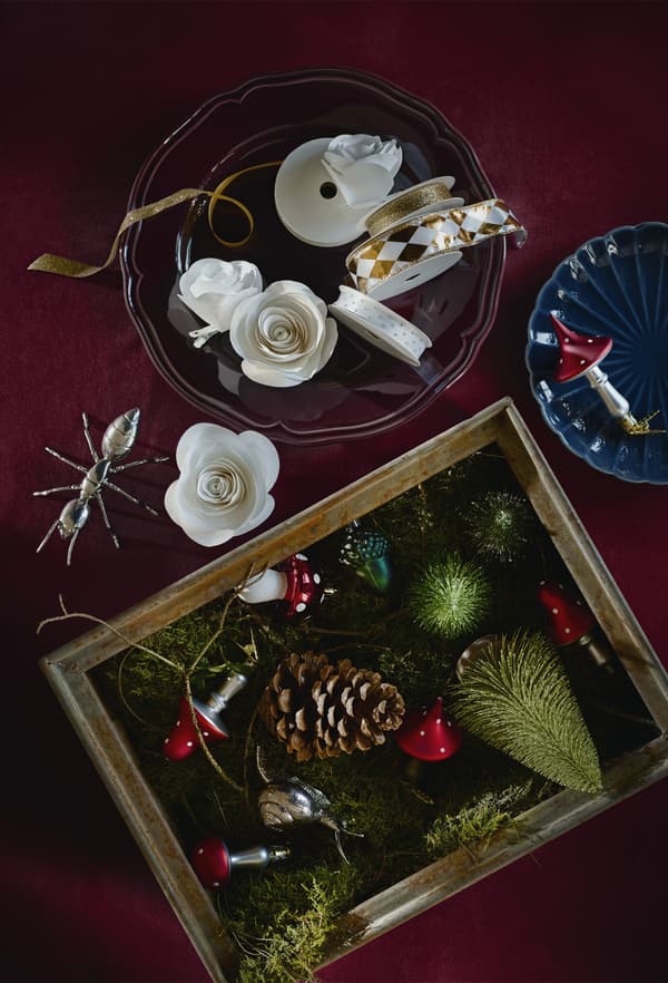 Décorations pour le sapin de Noël et rubans, dans des saladiers et des boîtes, sur une table.