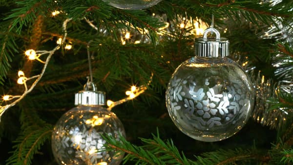 Decorazioni in vetro e lucine accese su un albero di Natale.