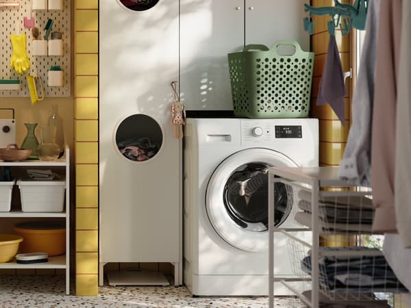 Deel van een wasruimte met een UDDARP wasmachine, een NYSJÖN kast voor wasmachine en een JONAXEL stellingkast.