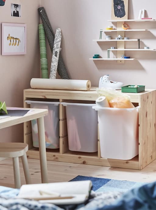 Deep storage bins in a light wood unit, with art supplies and shelves above.