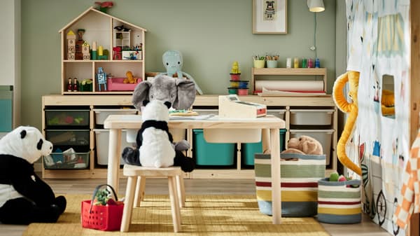 Dei peluche attorno a un tavolo in pino e sgabelli per bambini; due combinazioni di mobili con strutture in pino contenenti giocattoli vari.