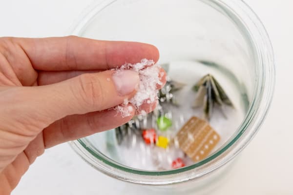 Dekoschnee wird über das Glas gestreut