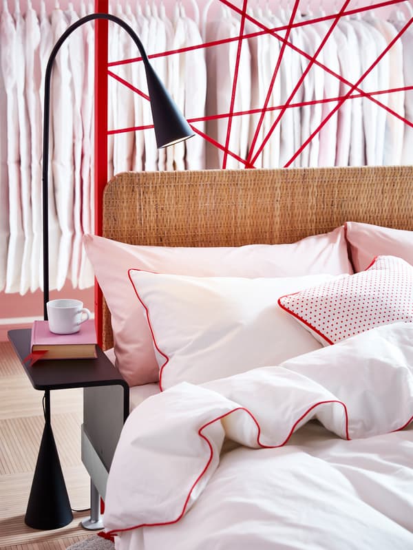 DELAKTIG LED floor lamp next to a DELAKTIG bed with DELAKTIG rattan headboard.