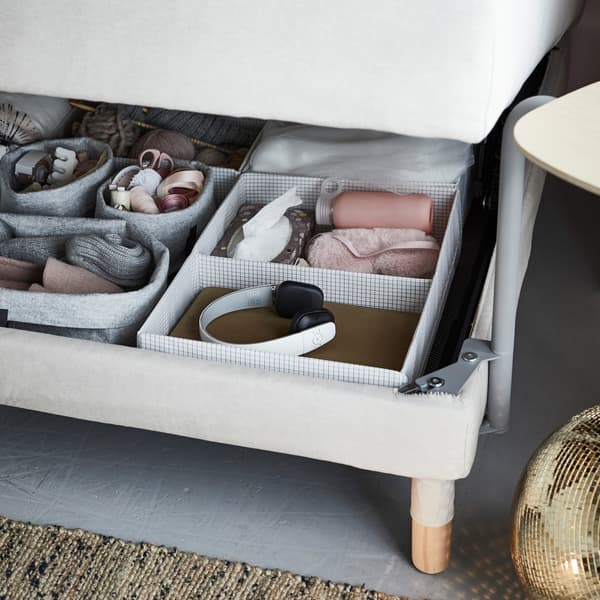 Dengan katil sofa berbilang fungsi, anda boleh menggunakan bekas storan STUK IKEA untuk menyimpan semua barang yang anda perlukan dalam capaian. Fikirkan tentang bekalan mengait, fon kepala dan topeng mata.