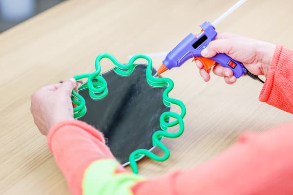 Der fertig geformte Rahmen wird mit Heißkleber auf den Rahmen geklebt.