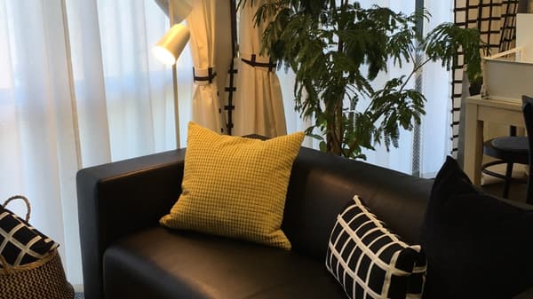 間接照明で照らされたソファスペースにクッションが並んでいる。