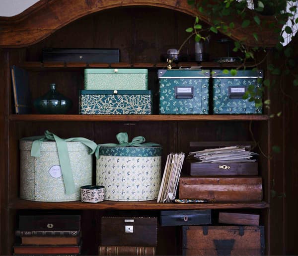 Des boîtes de rangement au motif naturel à l’intérieur d’une armoire en bois.