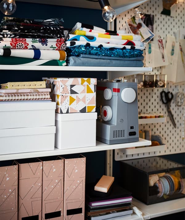 Des boîtes de rangement, des range-revues, des tissus et une machine à coudre