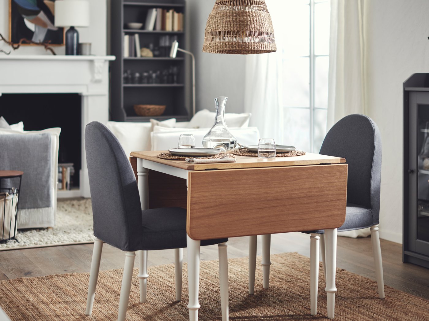 Des chaises de salle à manger DANDERYD autour d’une table à abattants DANDERYD en plaqué chêne blanc dans une pièce épurée et lumineuse.