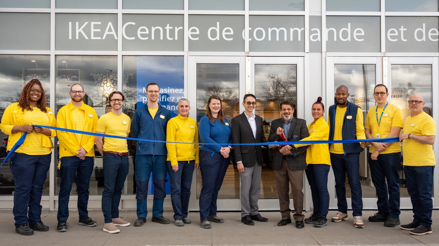 Des gens coupant un ruban à l'extérieur d'un nouveau magasin IKEA