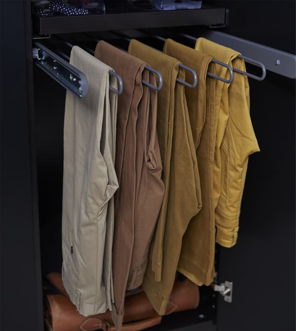 Des supports comme le porte-pantalons coulissant KOMPLEMENT de chez IKEA permettent de rassembler votre collection et facilitent les choix vestimentaires. Ce cintre en acier laqué par poudrage gris foncé à cinq tiges est conçu pour 10 à 15 pantalons.
