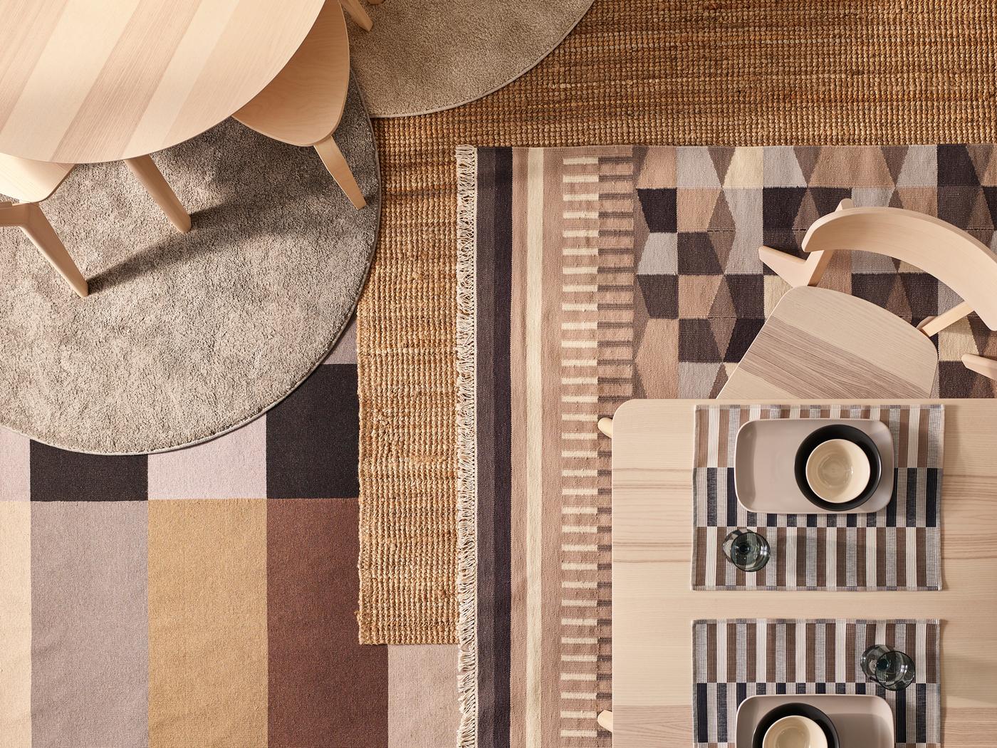 Des tables et chaises LISABO plaquées frêne sont disposées sur différents tapis, dont LOHALS et d’autres modèles à motifs.
