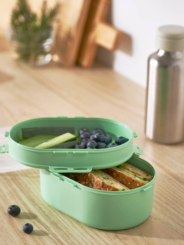 Desiata v zelenej dóze UTBJUDA, v pozadí stojí fľaša na vodu ENKELSPÅRIG.