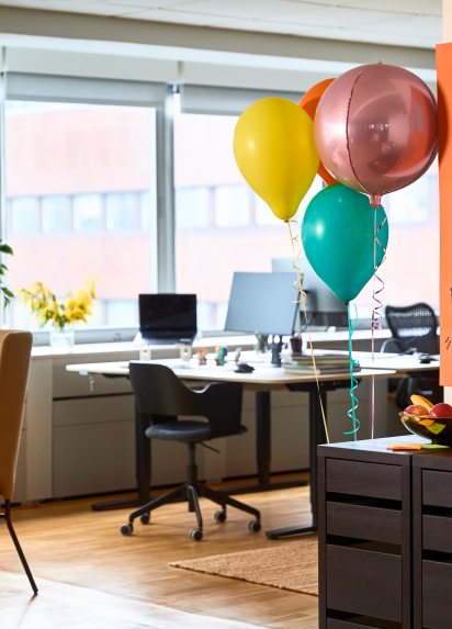 Desks in an office with balloons in the forefront