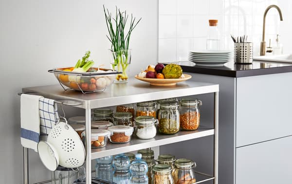 Desserte en métal sur roulettes aux tablettes remplies d’ingrédients, placée près du comptoir de la cuisine