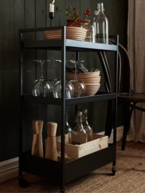 Desserte noire avec des verres à pied et des bols empilés