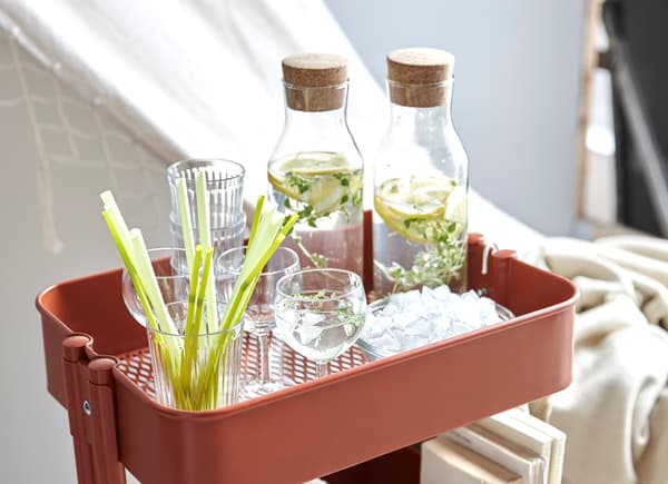 Desserte RÅSKOG utilisée pour transporter boissons, livres et musique de relaxation.