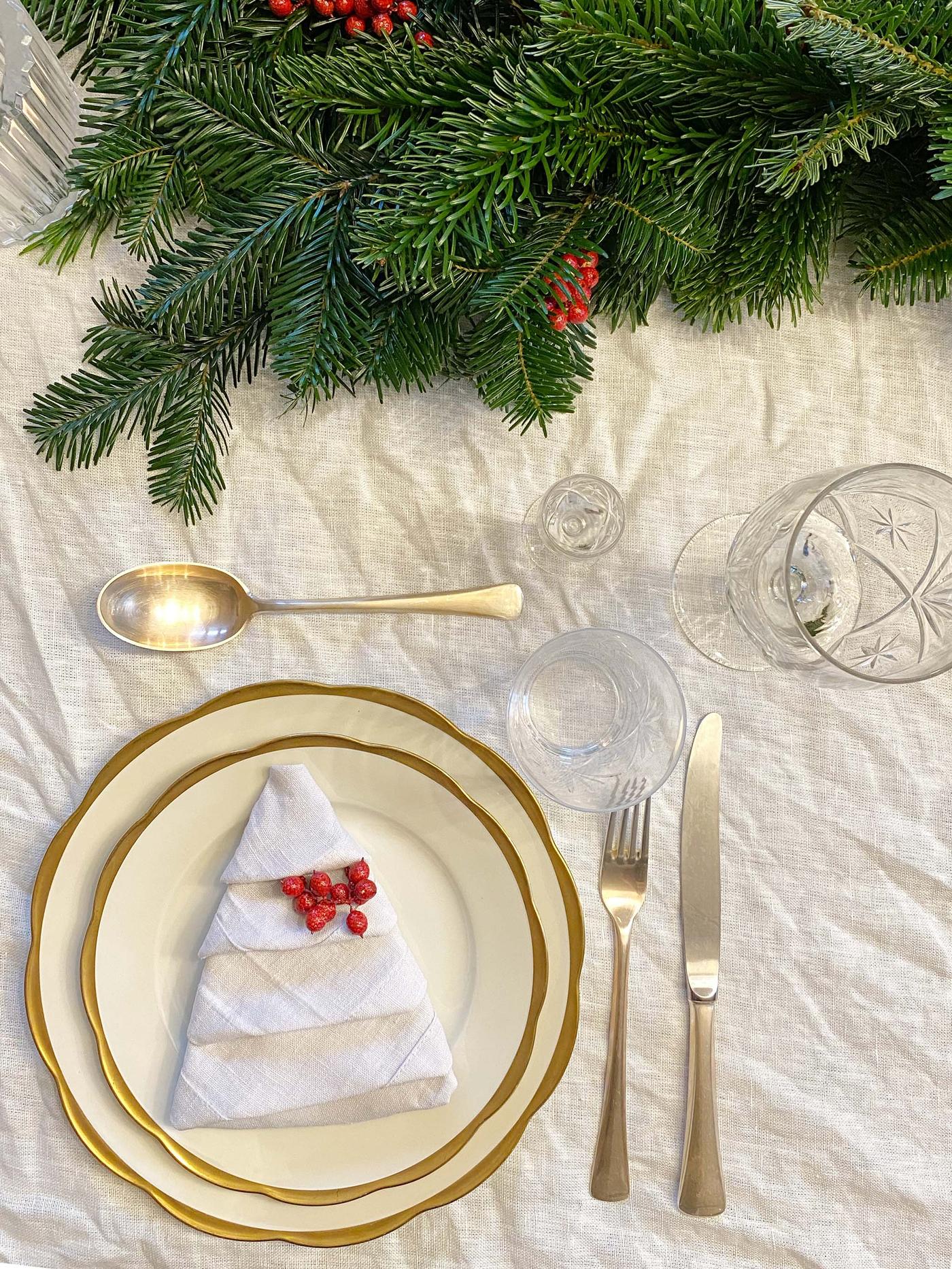 Det er dekket på til jul på en lys linduk som er krøllete.