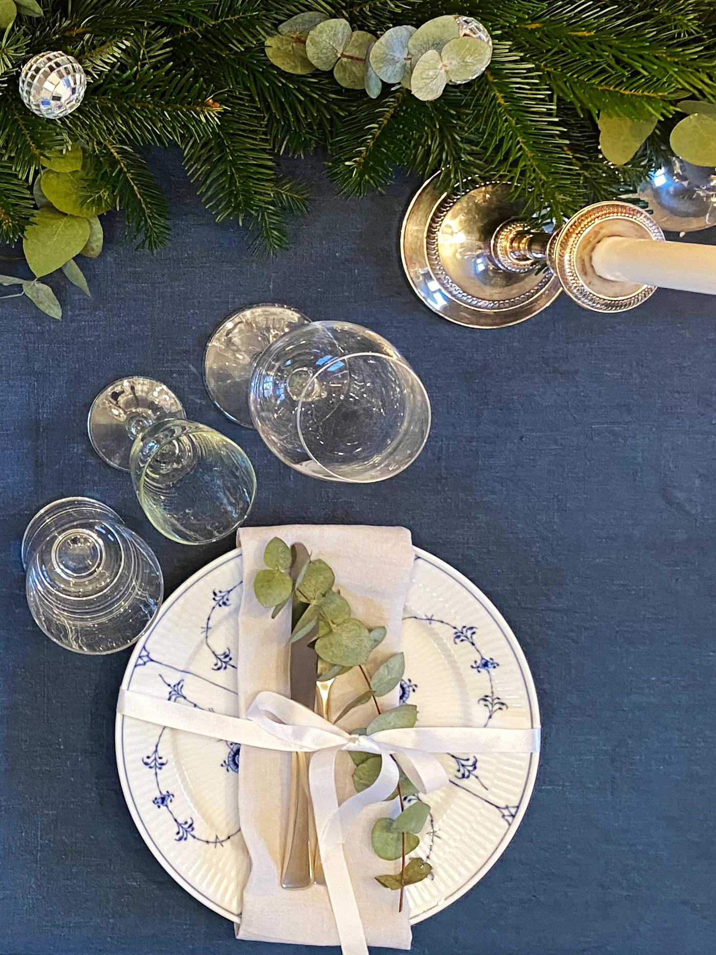 Det er dekket på til nyttårsmiddag, der duken er blå og uten en krøll