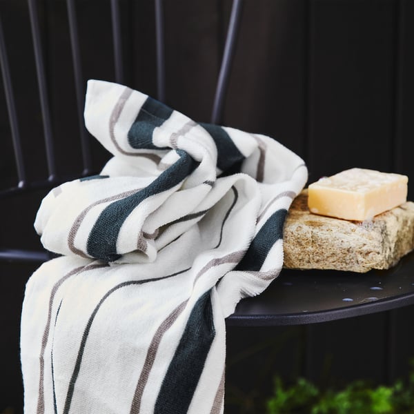 Detail ručníku OTTSJÖN s šedými a modrými proužky ze 100% udržitelné bavlny.