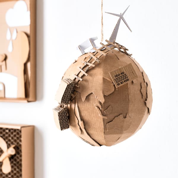 Detailansicht eines Globus aus Pappe mit Windrad-Modell als Symbol für Umweltbewusstsein und Nachhaltigkeit bei IKEA.

