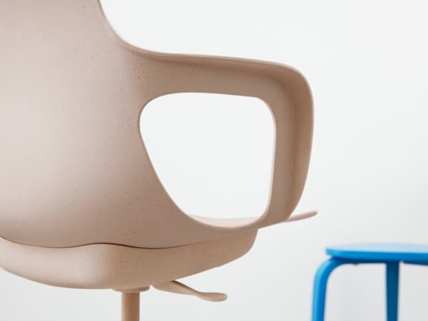 Detalle de la silla giratoria ODGER con su asiento cóncavo, respaldo redondeado y reposabrazos en blanco/beige o negro.