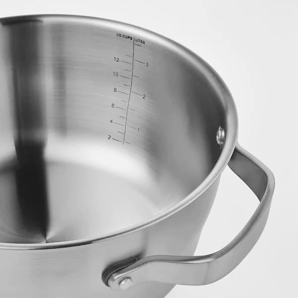 Detalle de una olla de acero inoxidable SENSUELL con un medidor marcado en su cara interior. 