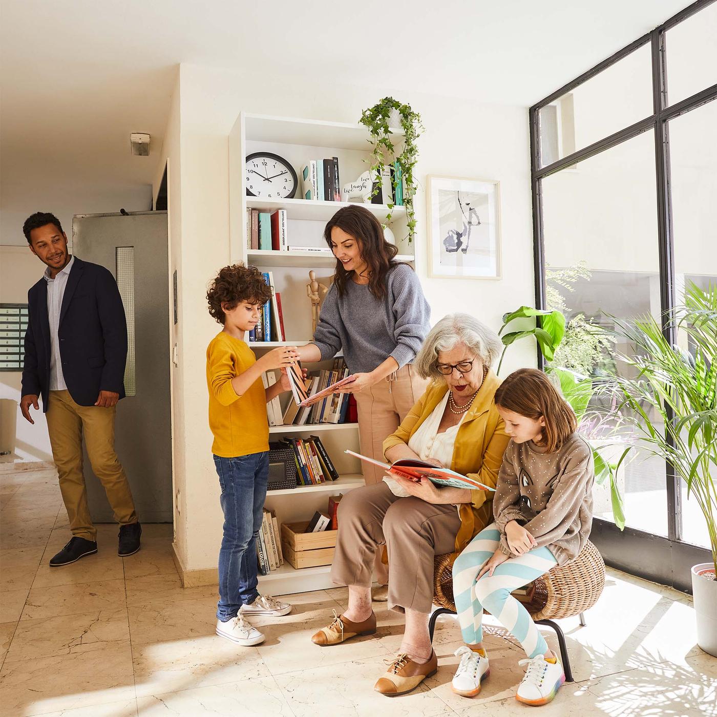 Deti a susedia čítajú na svetlom schodisku pred knižnicou BILLY.