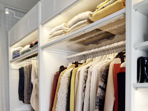 Dettaglio di un guardaroba PAX bianco con capi di vestiario ben ordinati e organzizzati.