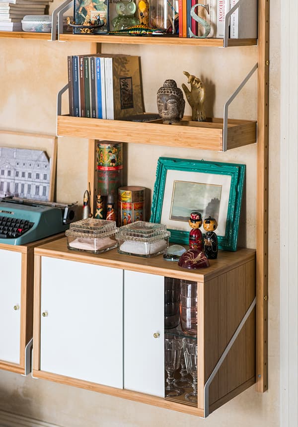 Dettaglio di una combinazione a parete di mobili EKET. Sui ripiani ci sono diversi oggetti tra cui una maccina da scrivere, cornici, libri e diverse decorazioni.