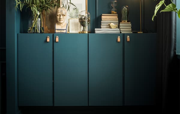 Deux armoires IVAR peintes de la même couleur que le mur accueillent livres, œuvres d'art, plantes et même une lampe.