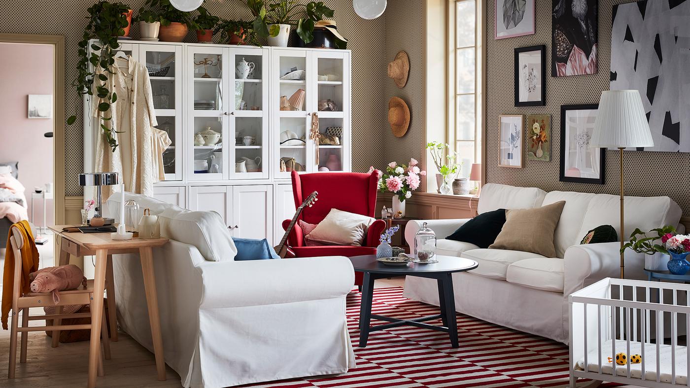 Deux canapés EKTORP sont placés l’un en face de l’autre dans un salon blanc et rouge moderne et traditionnel à la fois.