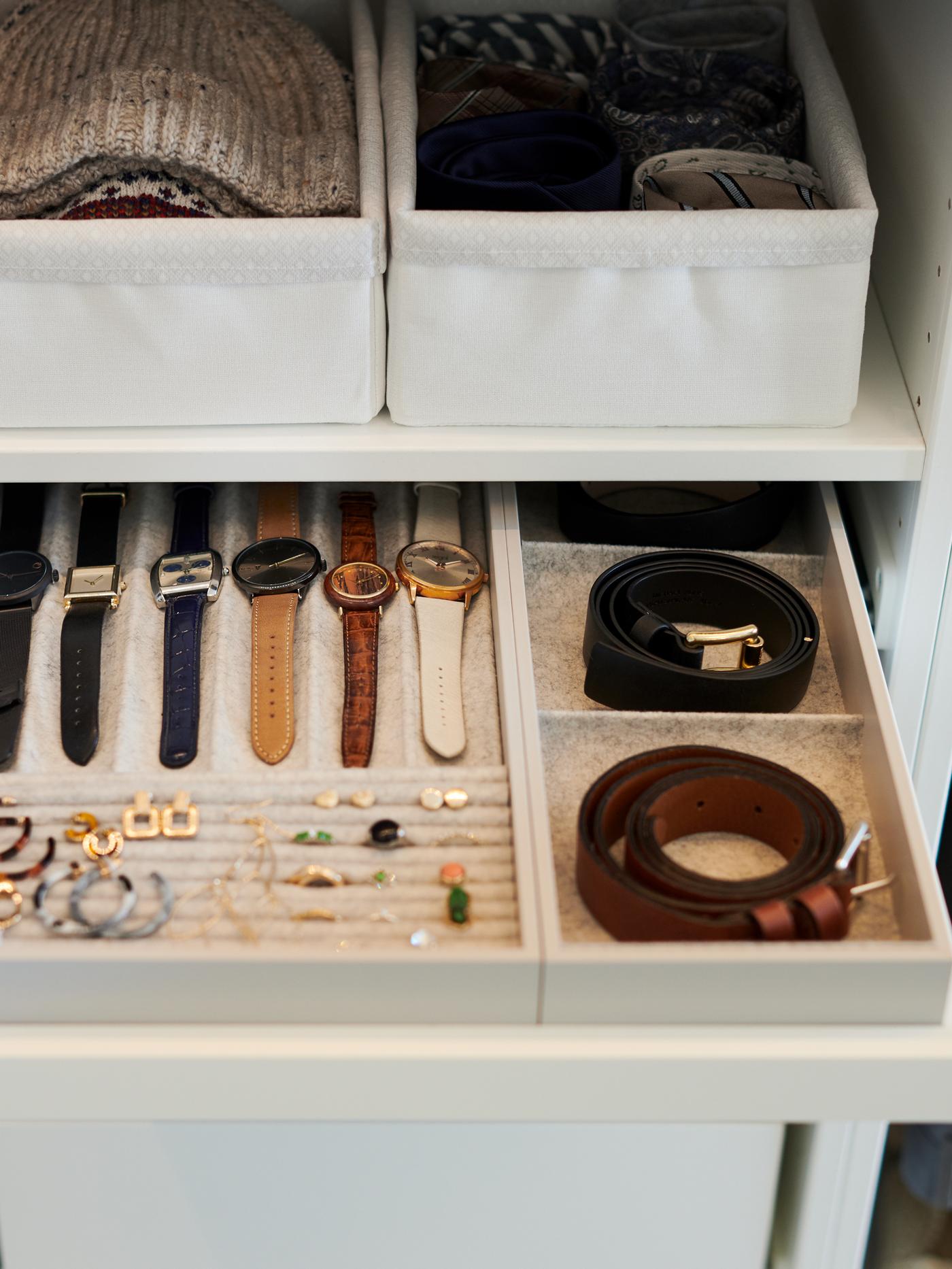 Deux ceintures, six montres et plusieurs paires de boucles d’oreilles dans un plateau coulissant KOMPLEMENT blanc avec insert.