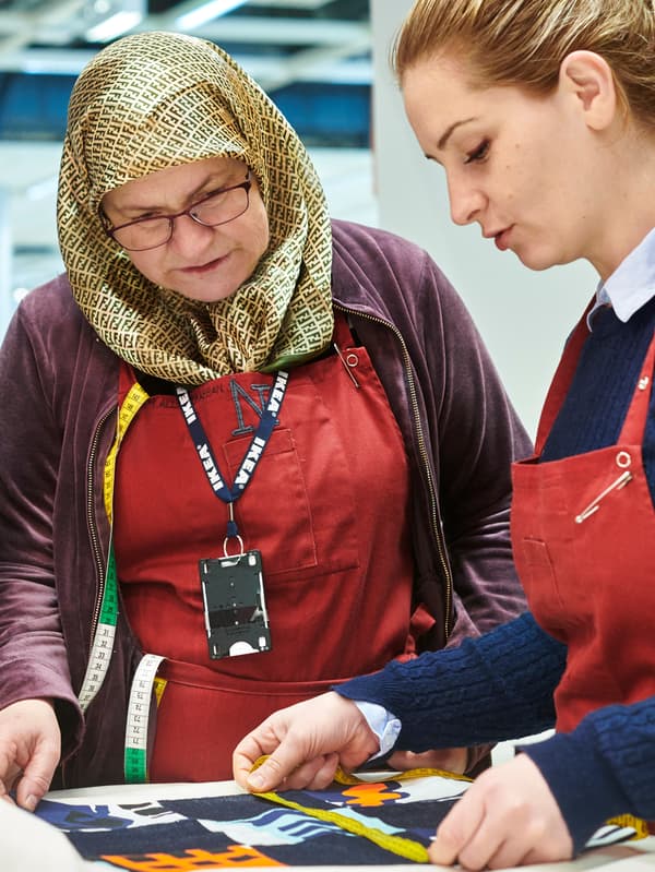 Deux collaborateurs de l’atelier de couture Yalla Trappan du magasin IKEA de Malmö (Suède) mesurent une longueur de tissu.