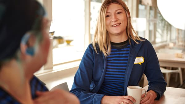 Deux collaboratrices IKEA en uniforme bleu qui profitent d’une pause dans la cafétéria du personnel.