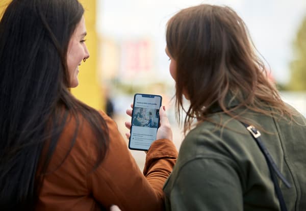 Deux femmes en train de regarder un téléphone.