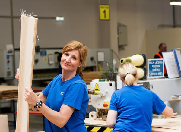 Deux femmes portants des t-shirts bleus travaillant avec des prototypes dans l'entrepôt d'un fournisseur IKEA.