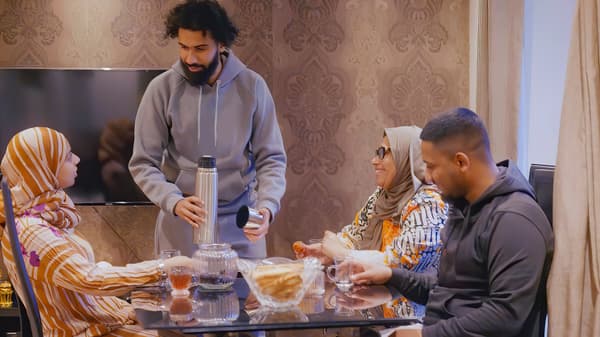 Deux générations d’une famille mangent gaiement à la table familiale.