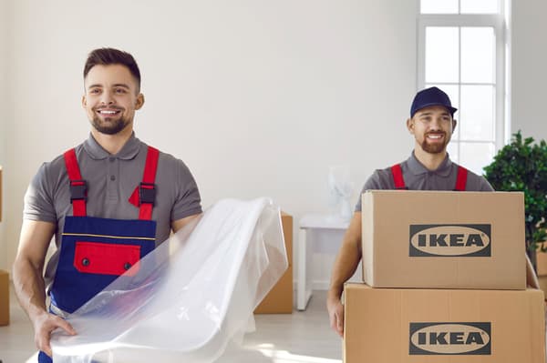 Deux livreurs amenant des articles IKEA à l’intérieur de la maison d’un client.