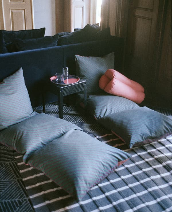 Deux longs coussins de sol et une table en métal noire.