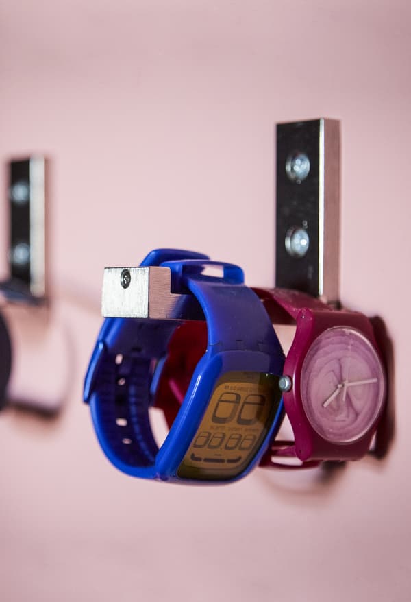 Deux montres accrochées à un crochet mural.