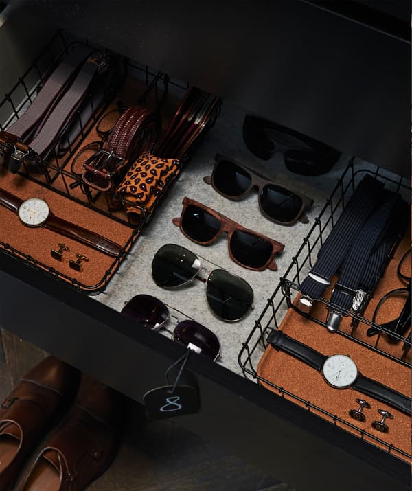 Deux organiseurs de bureau PLEJA en acier noir et liège utilisés pour ranger les ceintures, les montres, les lunettes et les bretelles dans un tiroir.