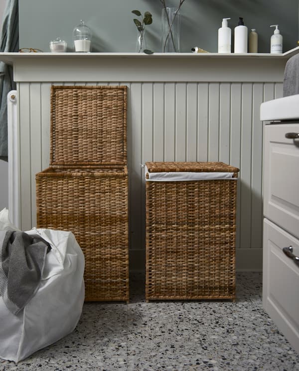 Deux paniers à linge en rotin BRANÄS avec doublure en tissu. Un panier est ouvert et sa doublure contenant du linge est posée à côté.