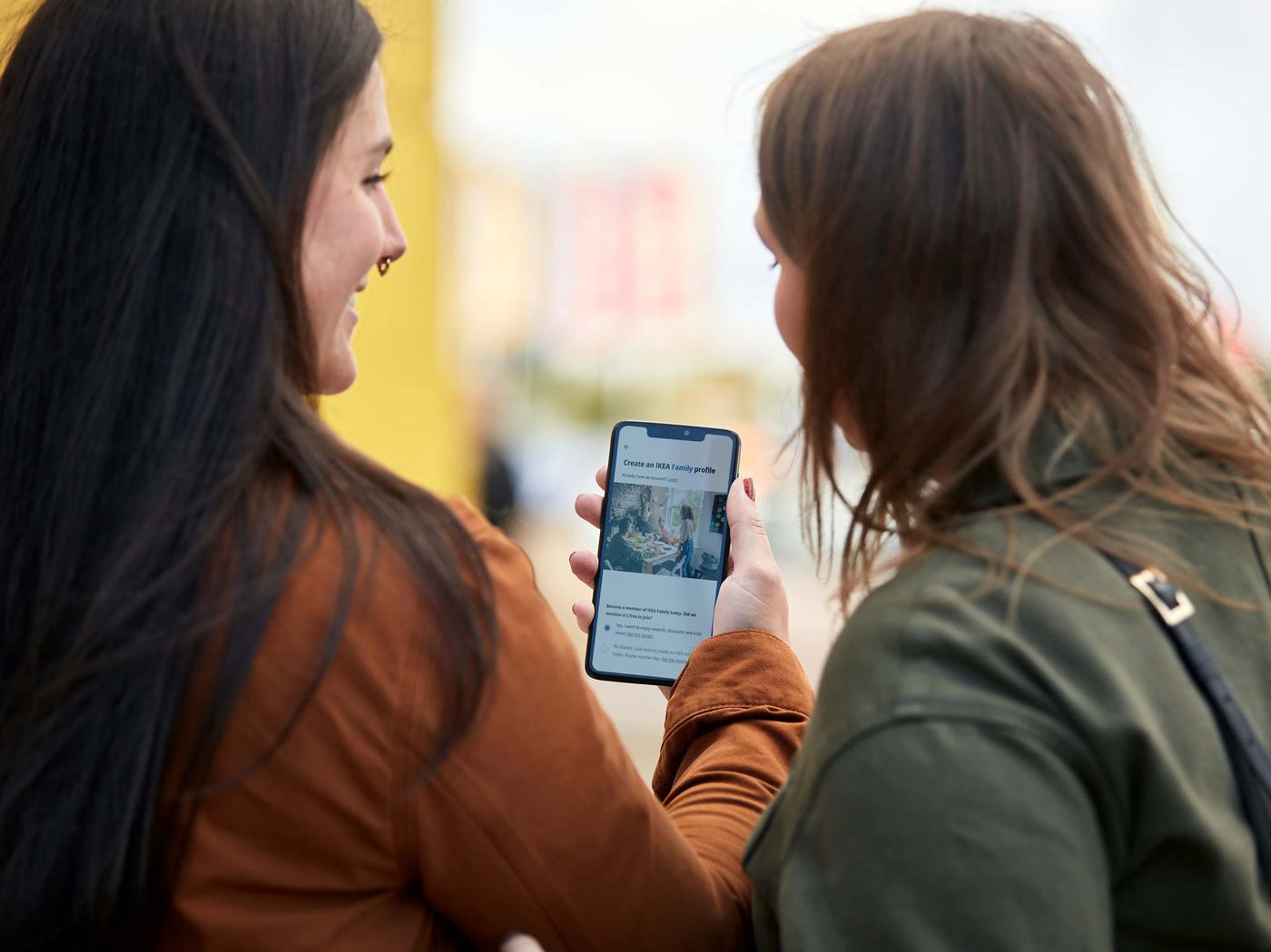Deux personnes regardant un téléphone mobile.