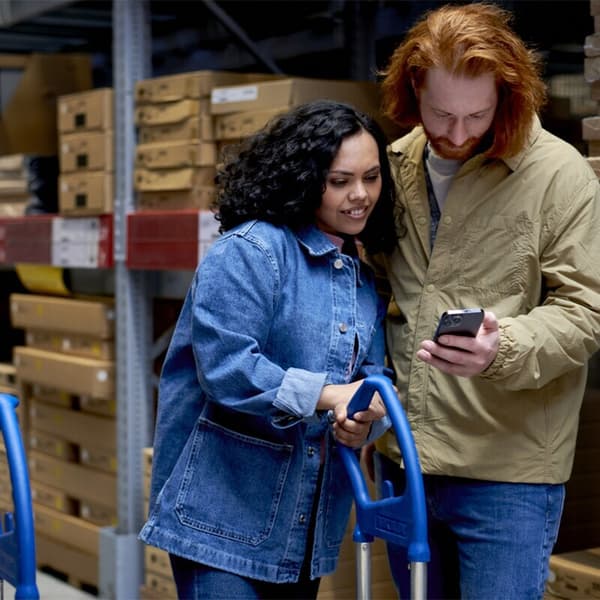 Deux personnes utilisant l'application IKEA pour passer plus rapidement en caisse 