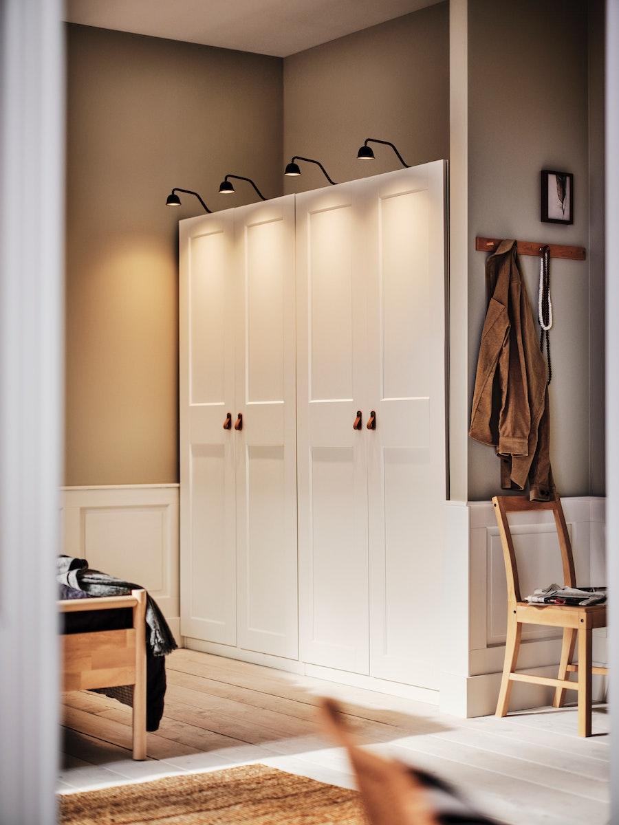 Deux placards à double portes côté à côté avec des lumières accrochées au dessus des placards.