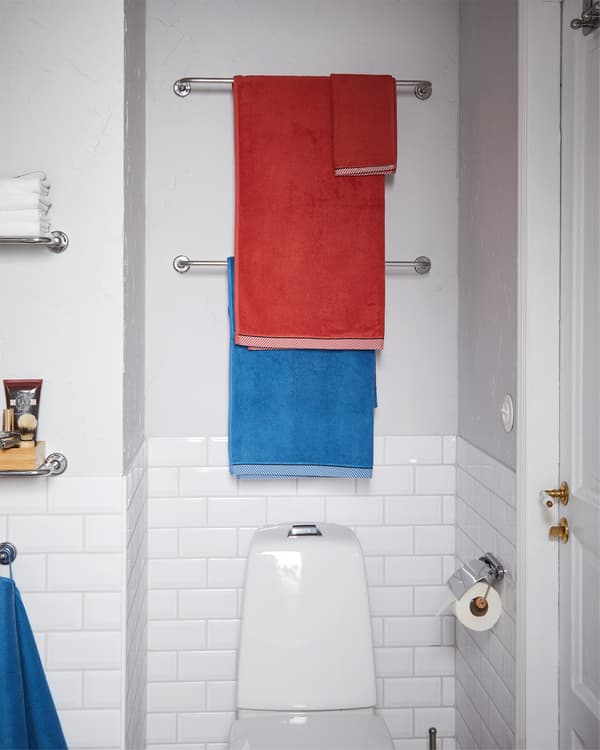 Deux porte-serviettes VOXNAN et leur finition chromée placés au-dessus de la cuvette.