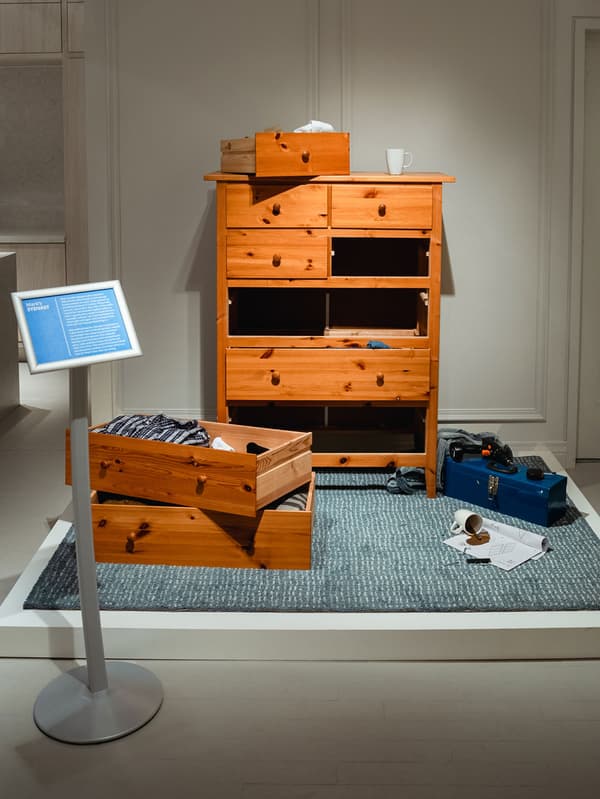 Deux tiroirs sont retirés d’une commode de présentation SYDVAST et sont posés l’un par-dessus l’autre sur le plancher de présentation.