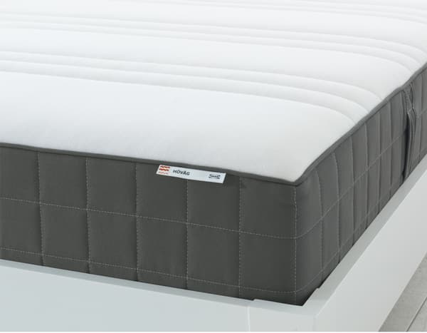 Die Ecke einer IKEA HÖVÅG Taschenfederkernmatratze, die auf der Oberseite weiss und an den Seiten dunkelgrau ist.